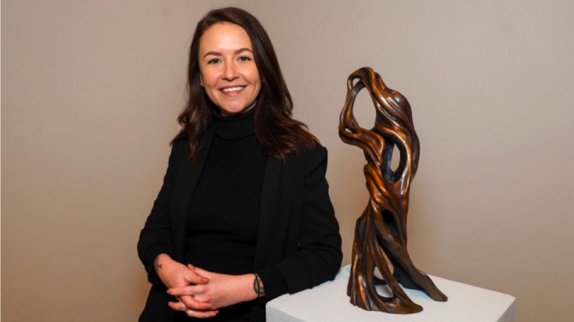 Graduate student Liz Johnson poses with one of her bronze sculptures that was exhibited as part of an MFA review