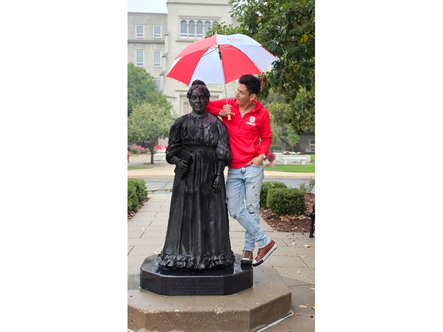 Rodrigo Alvarez Gonzalez poses in the rain with a statue of Lydia Moss Bradley.