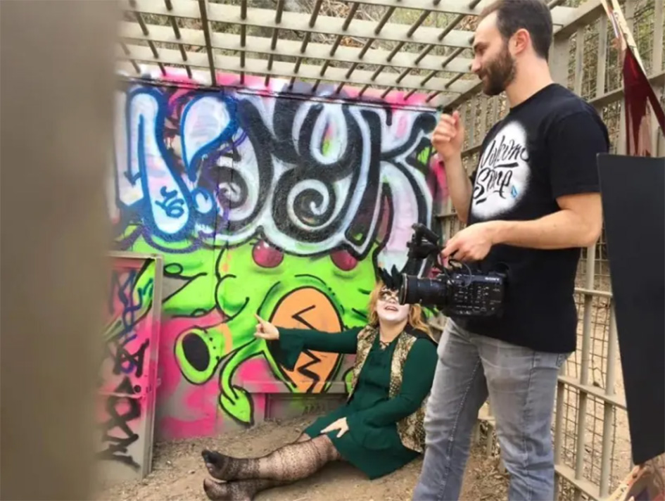 student with camera on music video set