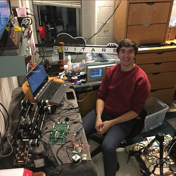 Kuzma in his dorm room at Bradley University, working on his self-playing robotic guitar
