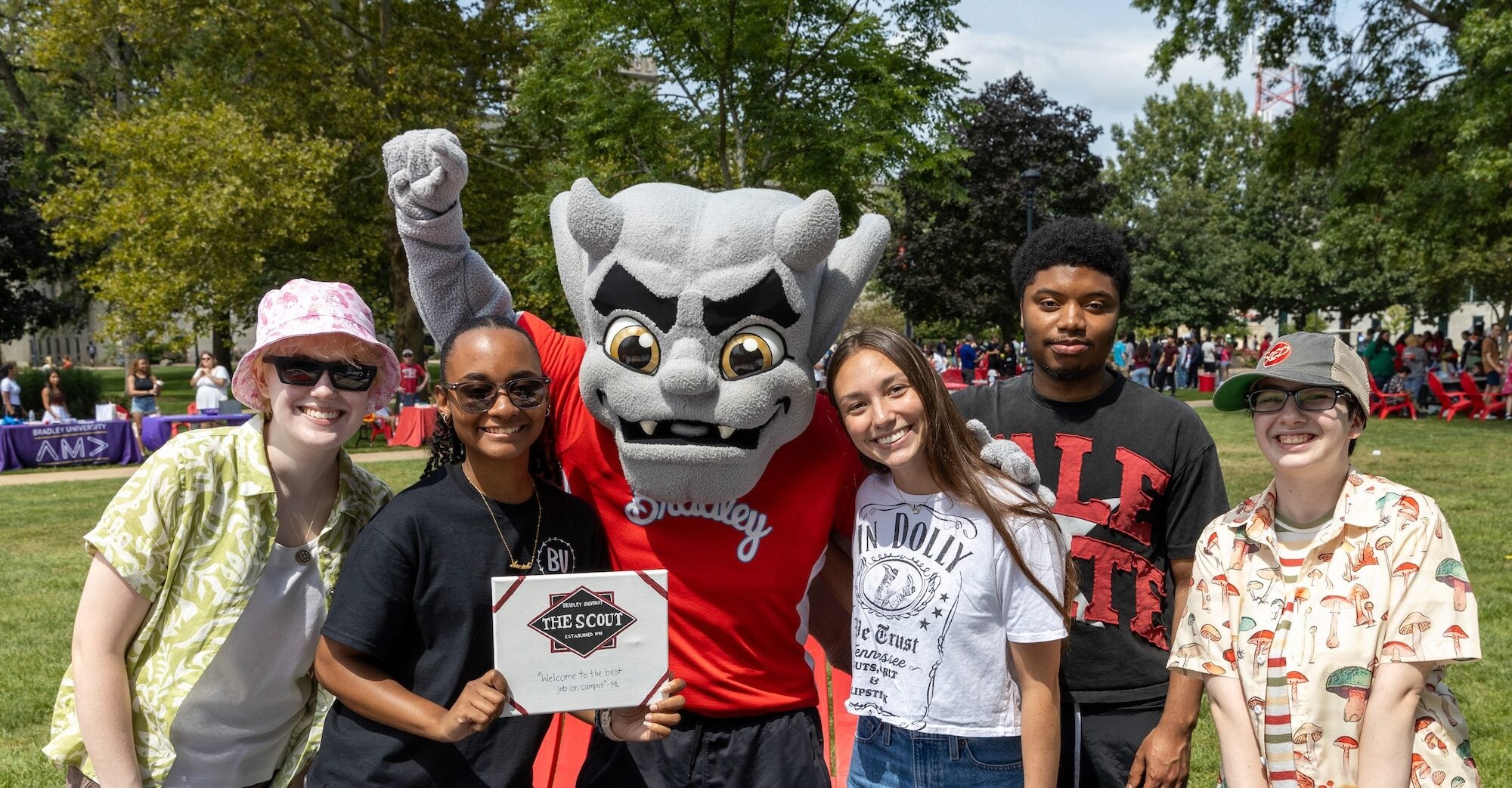 Students posing with Kaboom at the Scout Welcome Week booth on the campus lawn
