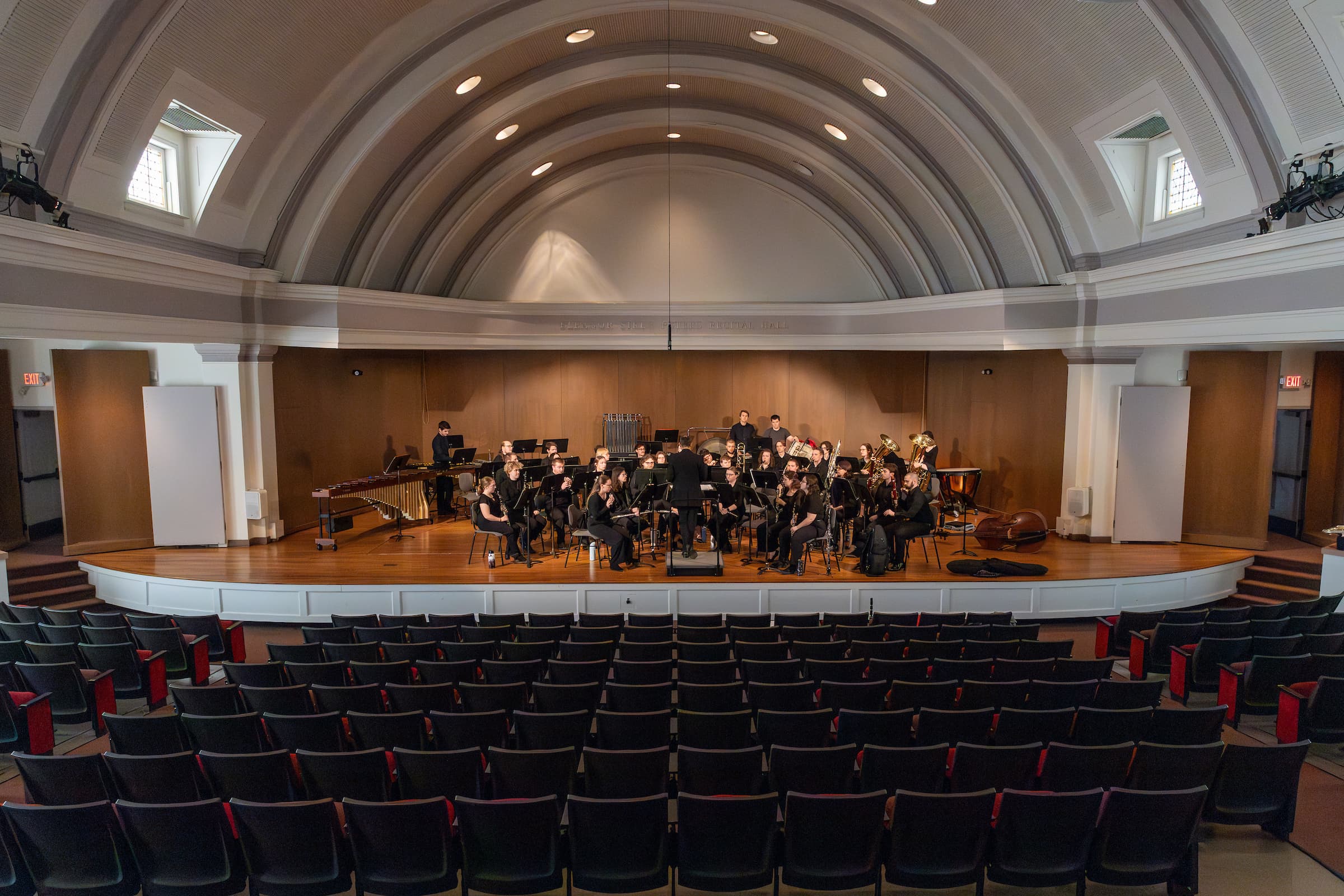 A full orchestra playing on stage inside the Dingeldine Music Center