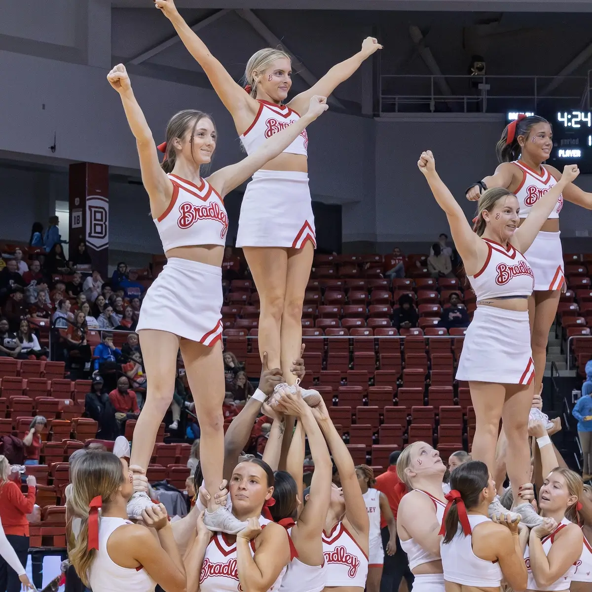 Cheerleaders forming 3 towers in a sports arena