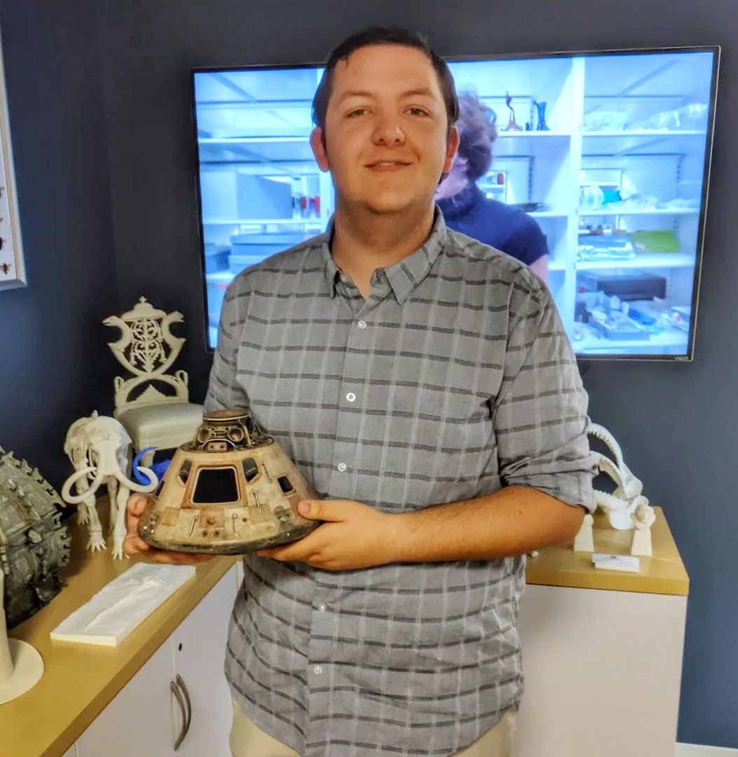 Andrew Barth holding a replica of the Apollo 11 crew hatch