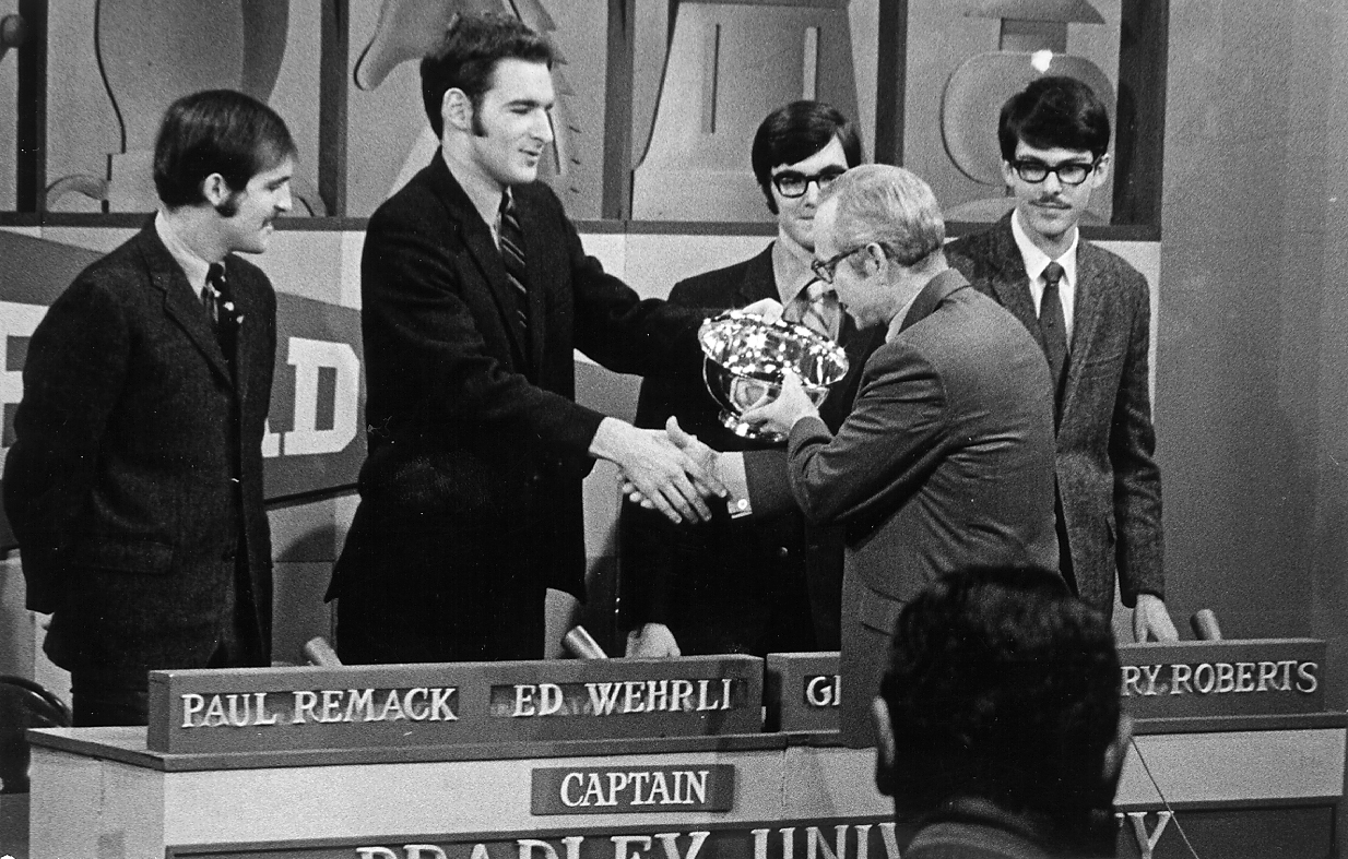 Bradley team Captain Ed Wehrli receives the G.E. College Bowl trophy from host Robert Earl, November 15, 1969. Bradley students Ed Wehrli, Gene Sidler, Paul Remack, and Gary Roberts were undefeated champions of the nationally televised G.E. College Bowl that year. The silver bowl they received is displayed in Bradley Hall.
