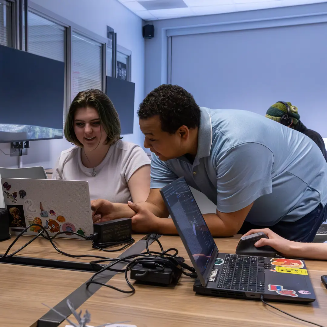 One student looking at another students computer screen