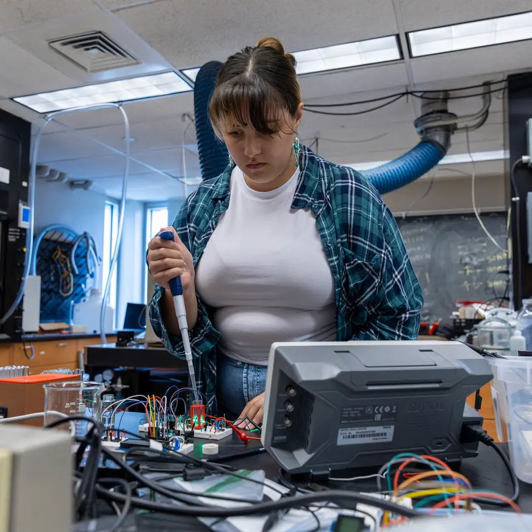 Female student in a lab with electrical equipment